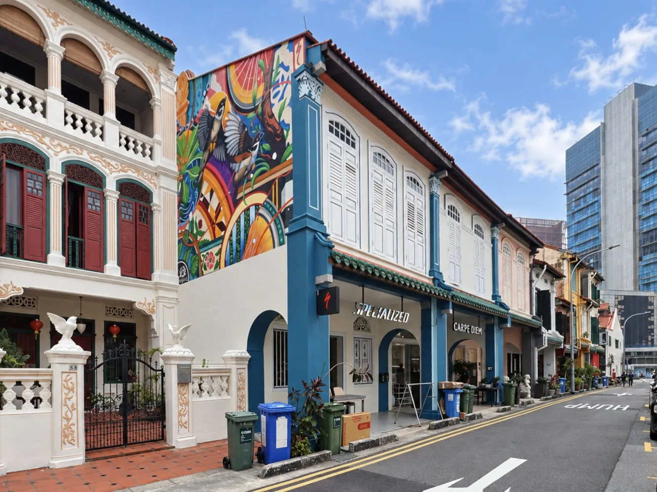 Street view of the adjoining conservation shophouses at 63 and 64 Spottiswoode Park Road, teal columns and white louvred shutters, with a painted mural on the end wall